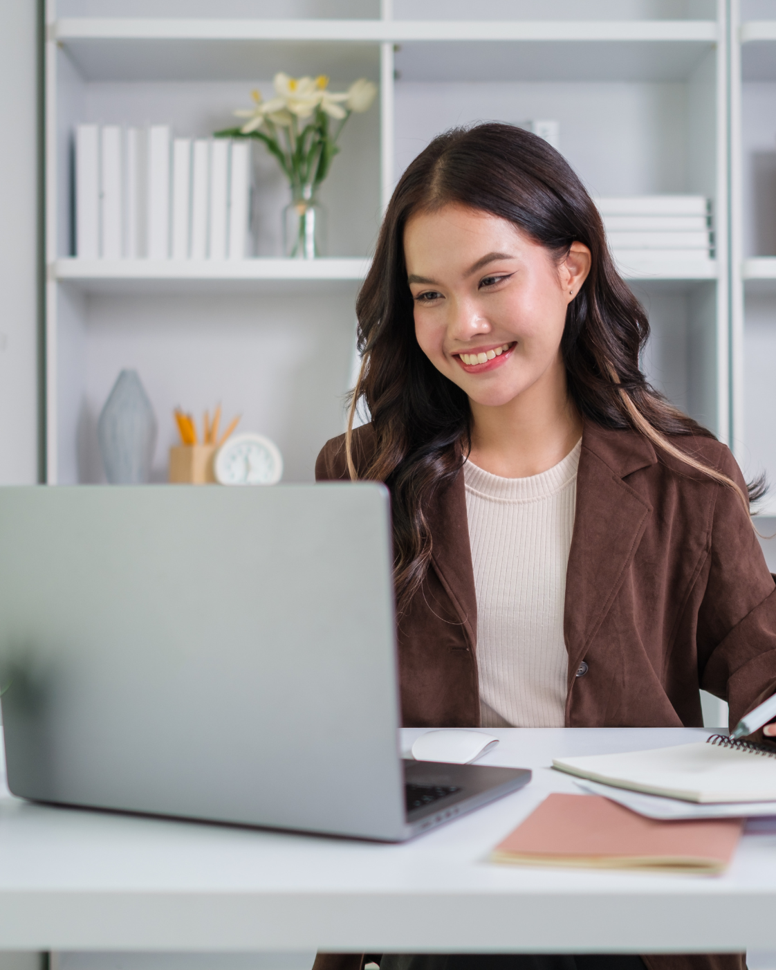 Indian virtual executive assistant managing business operations remotely from a modern office workspace with laptop and headset.